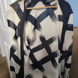 Beautiful beige and black top. Has 2 openings on each sleeve . Very flattering .